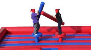 Joust - Two contestants climb onto 4' pedestals and try to knock each other off onto an inflatable mattress using a jousting stick.
