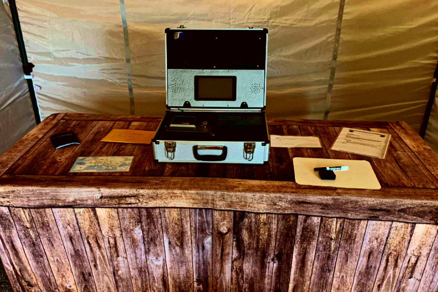 in-person escape room props for immersion. image shows a briefcase on a wooden table with letters and memos that will help the sleuths solve the case